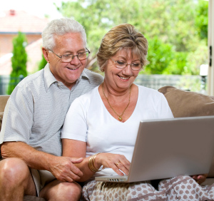 Senior couple using a laptop on the couch